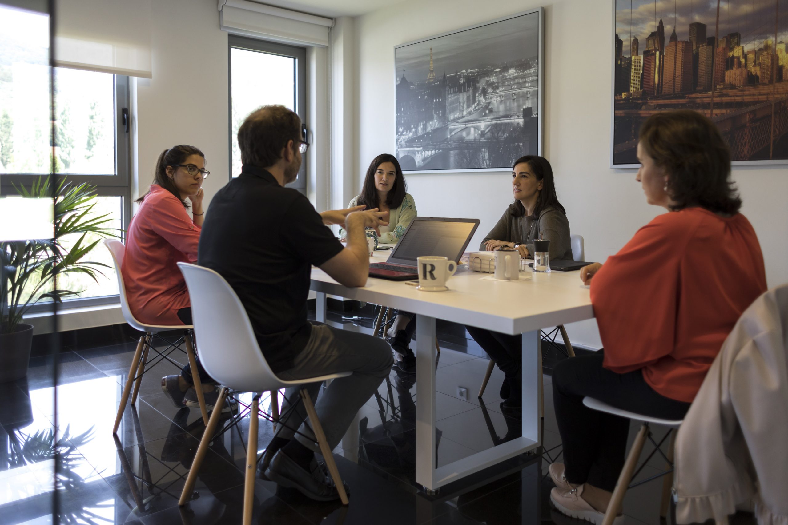 Equipo de 5 personas en una mesa compartiendo ideas