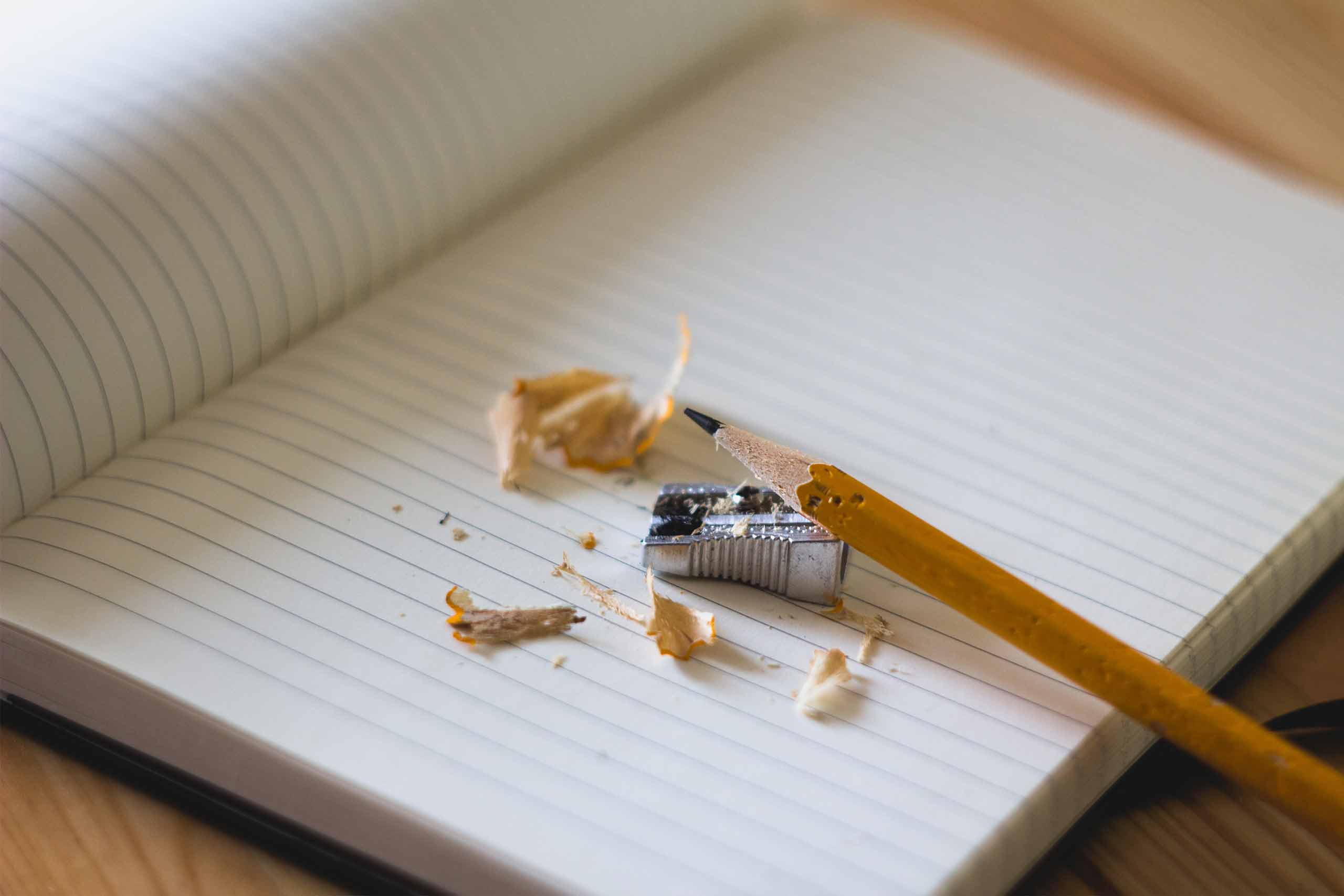 lápiz con sacapuntas y cuaderno del colegio