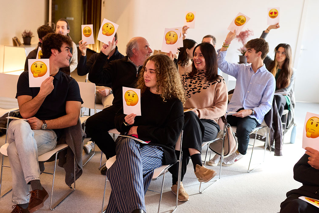 Asistentes a evento sobre marketing y comunicación levantan tarjetas con emojis